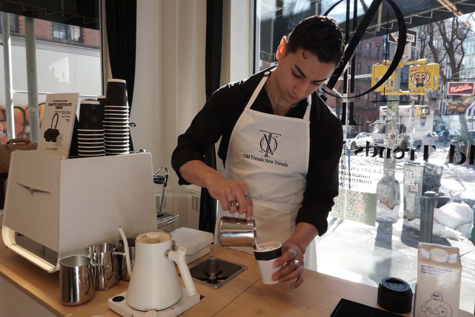 Odyssey barista pouring a custom branded latte at an activation