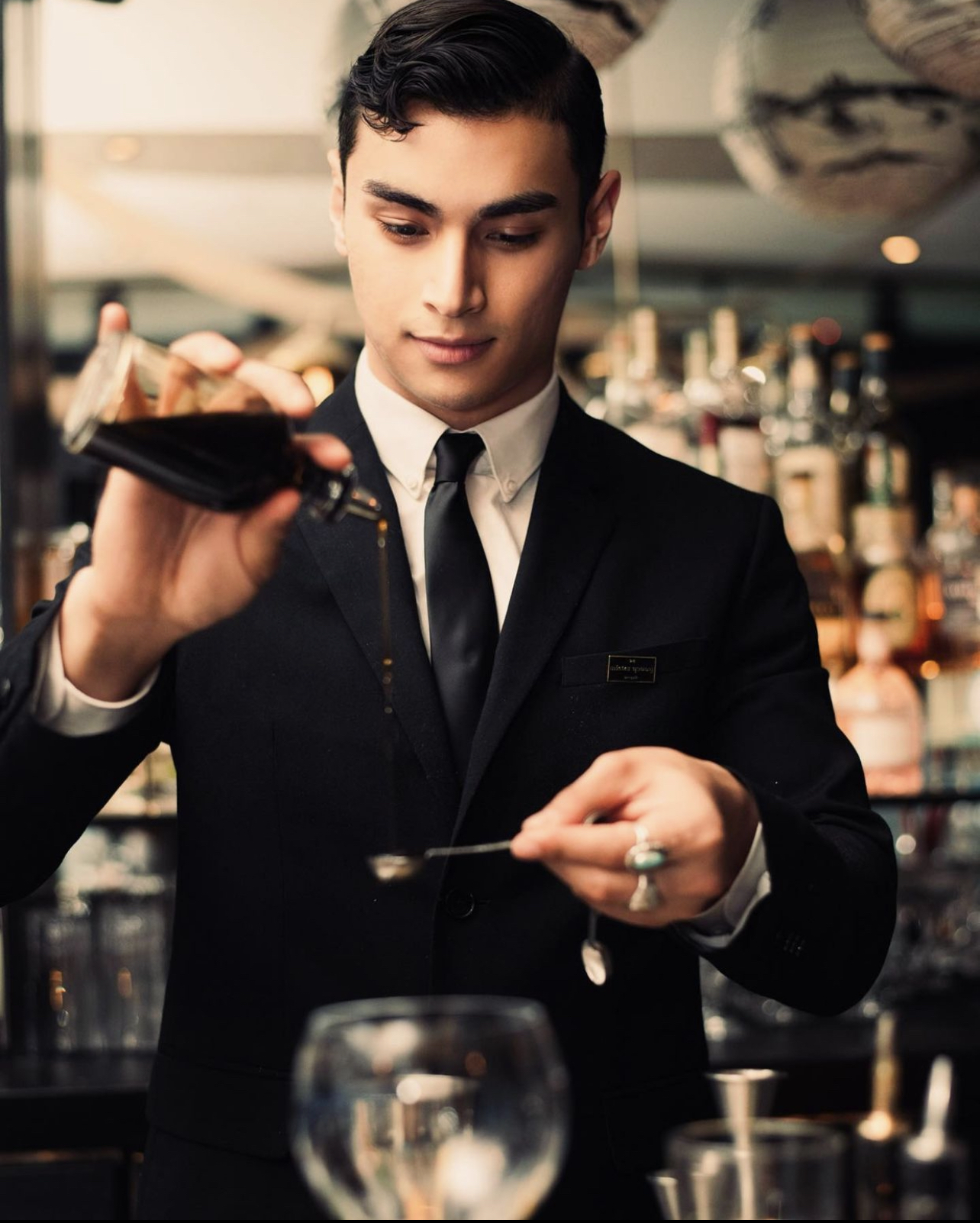 Angelo crafting a cocktail at a bar