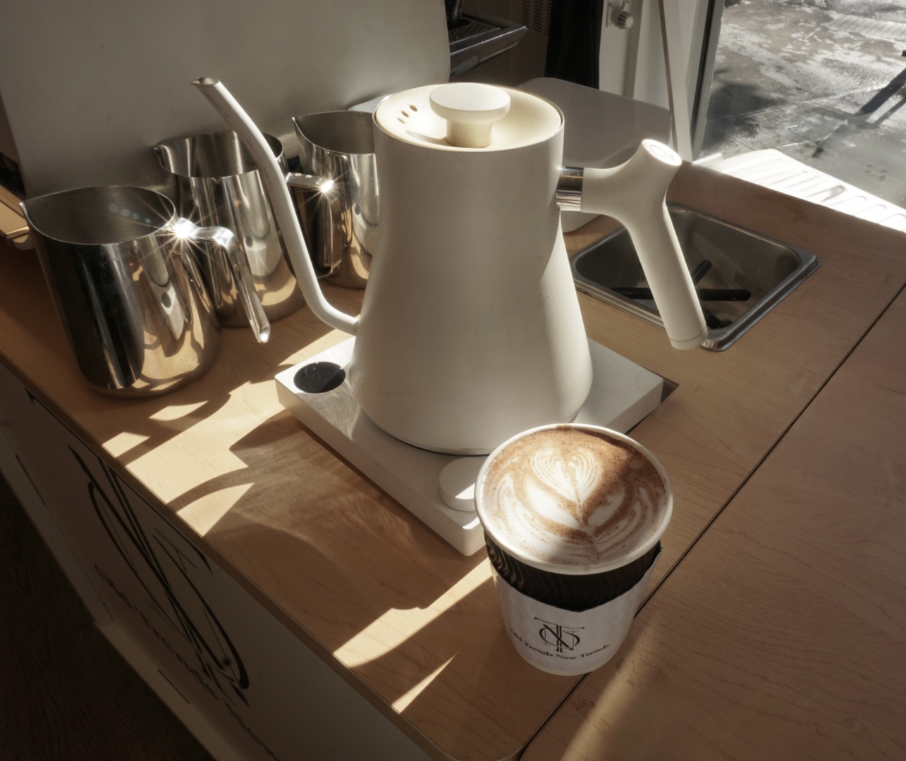 Cappuccino beside a pour-over kettle